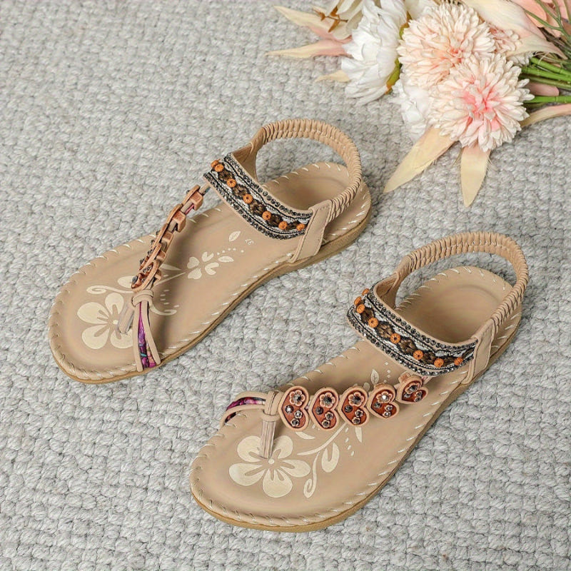Women’s ethnic beaded sandals in tan with rhinestone strap trim and bow accents.