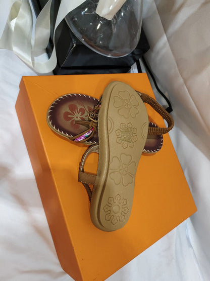 Women’s ethnic beaded sandals and a spare insole, shown on orange box.