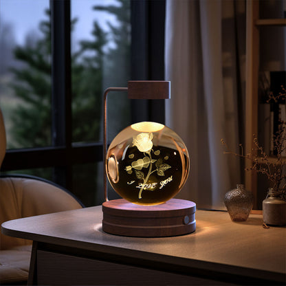 Decorative lamp with a rose design inside on a table.