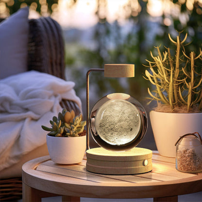 Crystal ball LED night light on round wood base with glowing sphere in clear glass