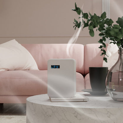 Air purifier on a marble table with a pink sofa and plant in the background