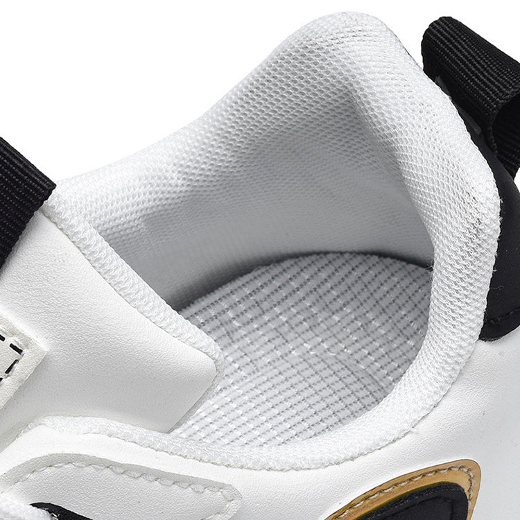 Close-up of a white sneaker with black accents and visible brand logo.