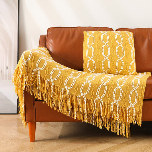 Mustard yellow knitted throw blanket with white lattice pattern and fringe tassels