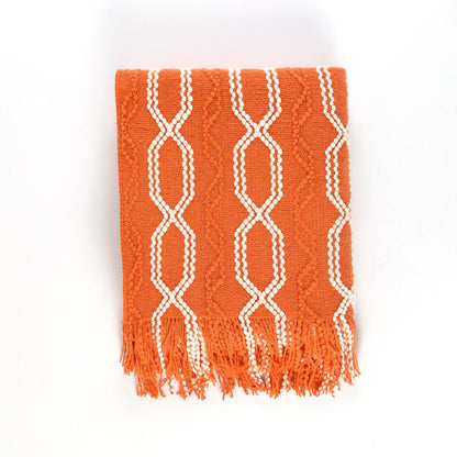 Orange knitted throw blanket with white lattice pattern and hanging fringe tassels