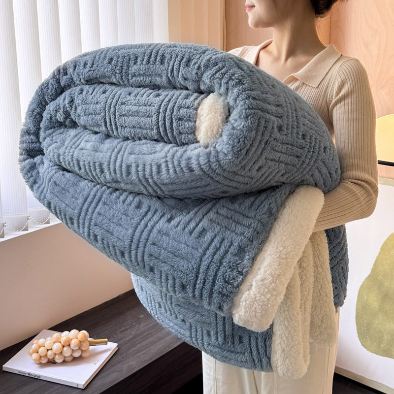 Person holding a large blue textured blanket with white lining