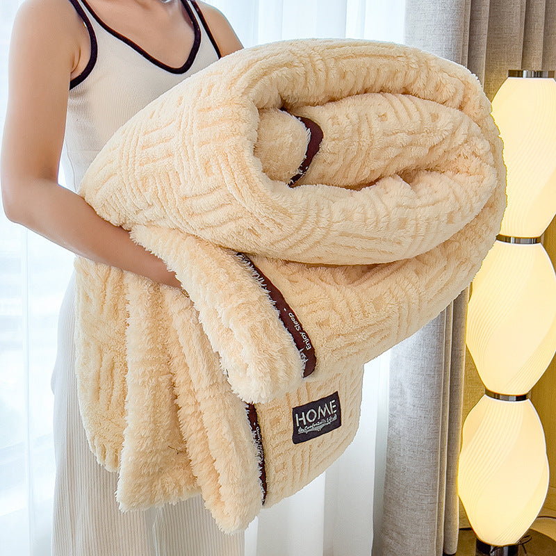 Person holding a beige blanket with 'HOME' label in a cozy room.