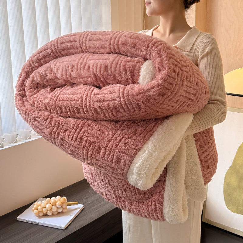 Person holding a large pink textured blanket indoors.