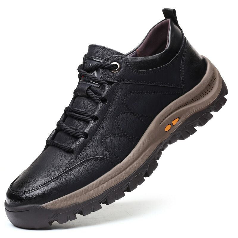 Black leather shoe with a brown sole on a white background