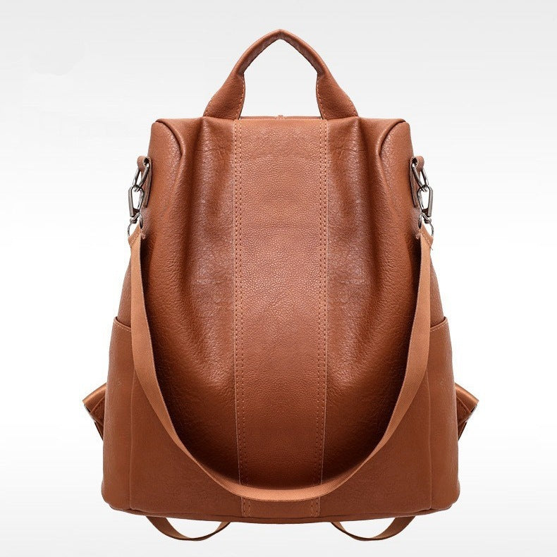 Brown PU leather backpack with top handle, side straps, and front zipper details