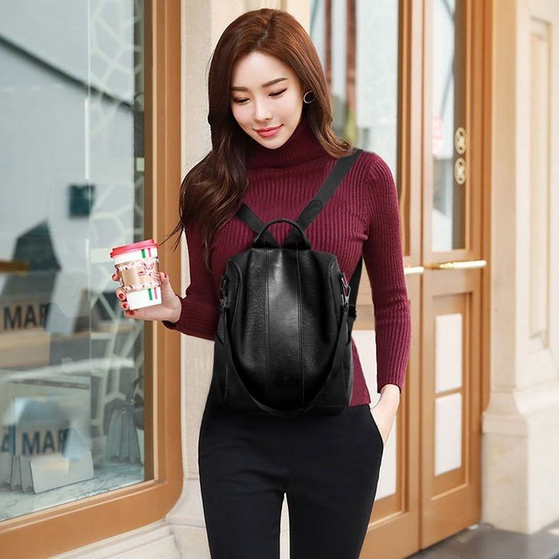 Woman wearing a black backpack holding a product in front of a store window.