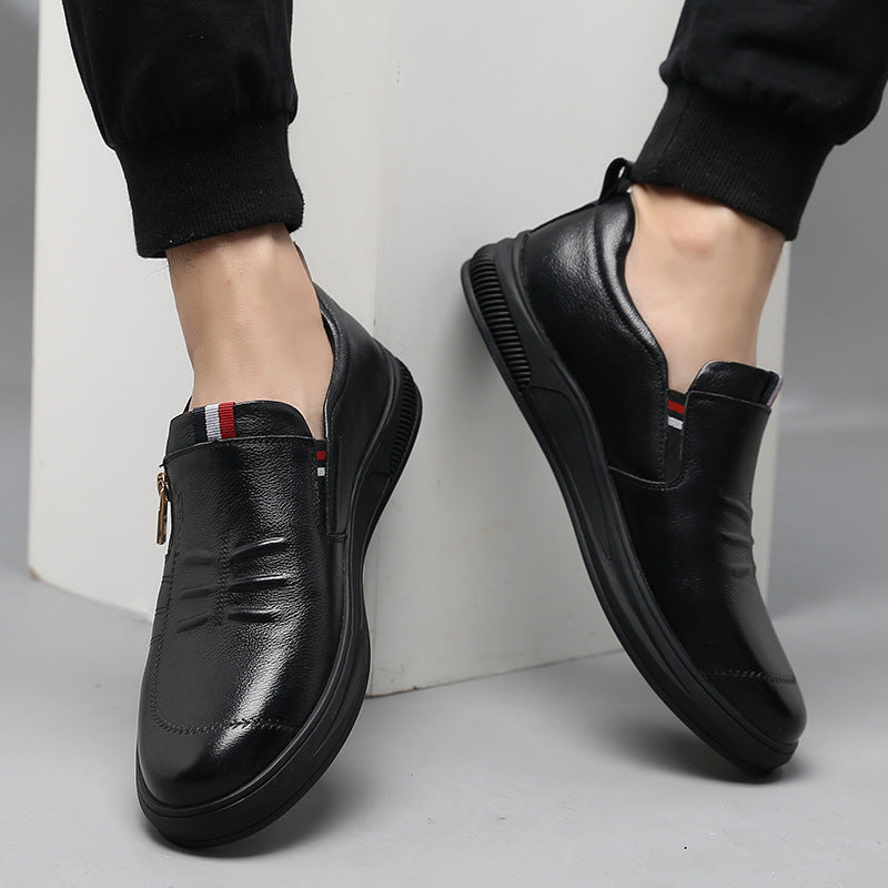 Black leather shoes worn by a person on a light gray background