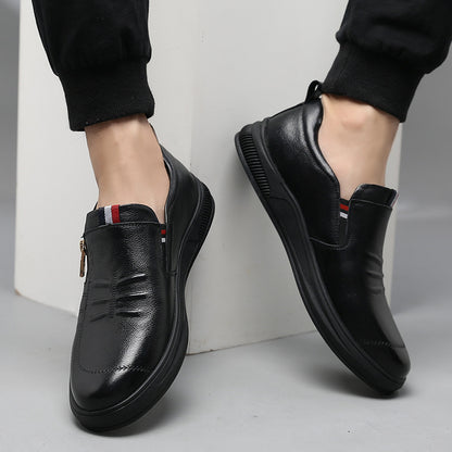 Black leather shoes worn by a person on a light gray background