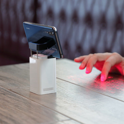 White phone stand with a smartphone on a wooden surface, blurred background
