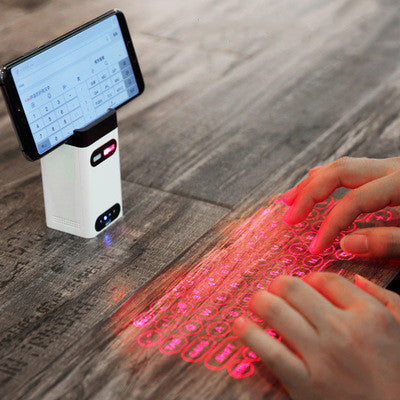 Person using a smartphone with a laser keyboard projection on a wooden surface