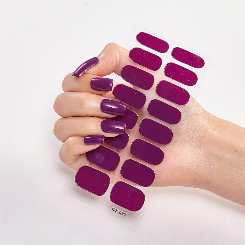 Hand holding a set of purple nail polish samples against a white background