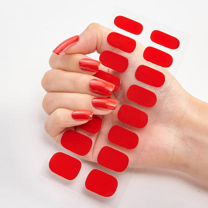 Hand with red nail polish and additional red nail patches on a white background