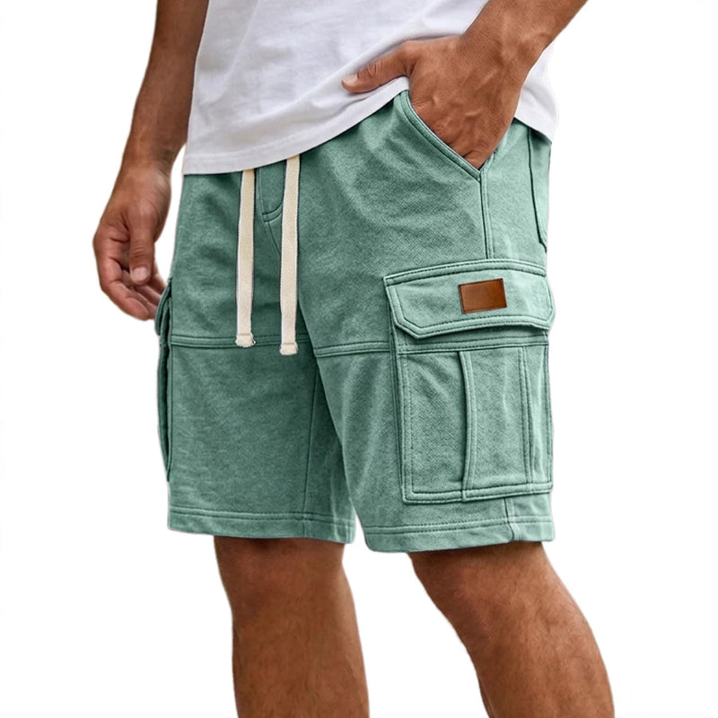 Green shorts with pockets and drawstring on a white background