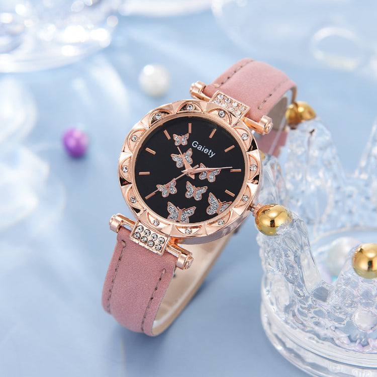 Pink watch with rose gold accents on a light blue background
