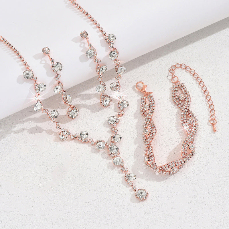 Rose gold necklace and bracelet set on a light background