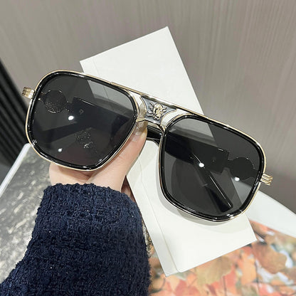 Sunglasses held by a hand with a blurred background