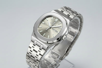 Silver watch with a metal bracelet on a beige surface, featuring a certificate of conformity.