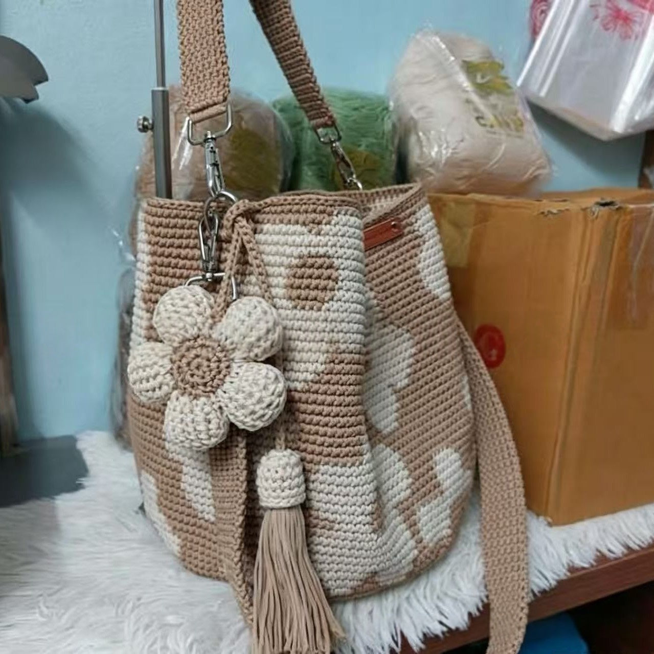 Hand-crocheted flower tote bag in beige with stacked white-tan blossoms and tassel pull