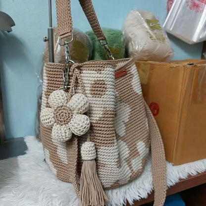 Hand-crocheted flower tote bag in beige with stacked white-tan blossoms and tassel pull