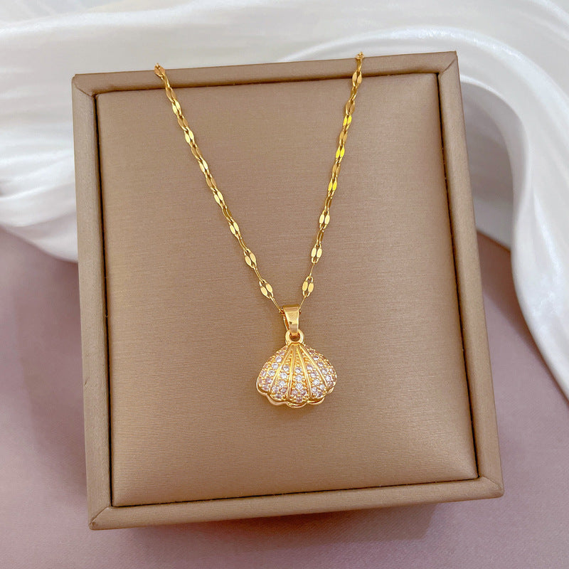 Women's Gold necklace with a shell pendant on a beige display box.