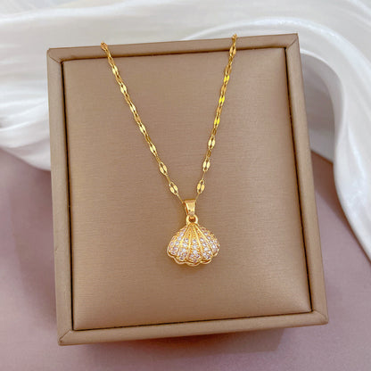Women's Gold necklace with a shell pendant on a beige display box.