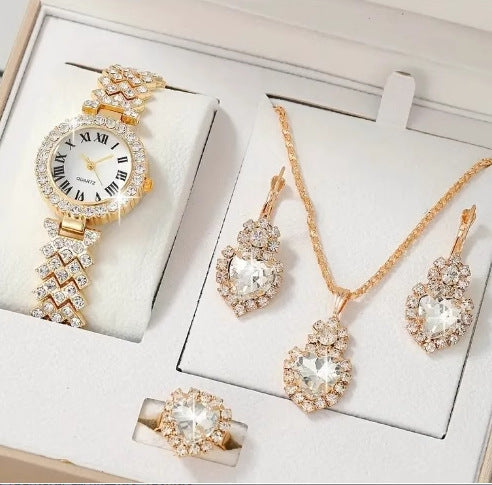 Rose gold jewelry set including a watch, necklace, and earrings on a white surface.