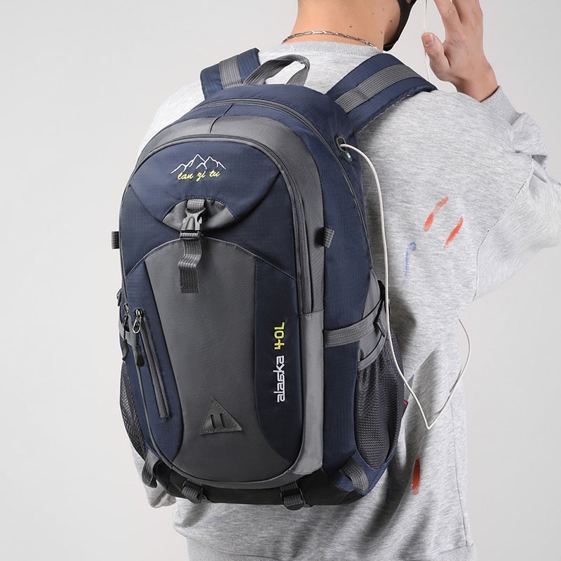 Person wearing a navy blue and gray backpack with visible branding on a light gray background