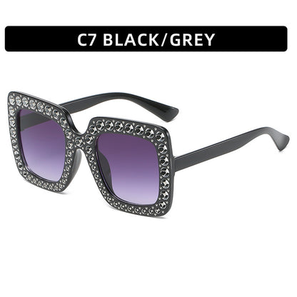 Sunglasses with decorative frame and purple lenses on a white background