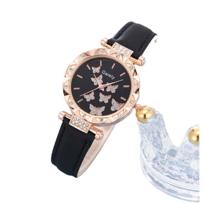 Wristwatch with black strap and rose gold case on a white background