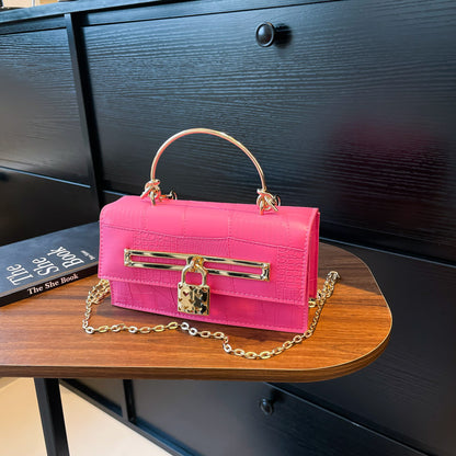 Women’s chain crossbody bag in bright pink PU leather with gold-tone lock charm and chain