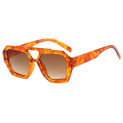 Orange tortoiseshell sunglasses with brown lenses on a white background