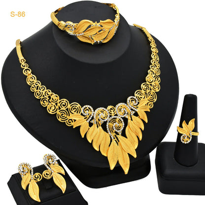 Gold-plated necklace with leaf motifs and matching earrings on a display stand