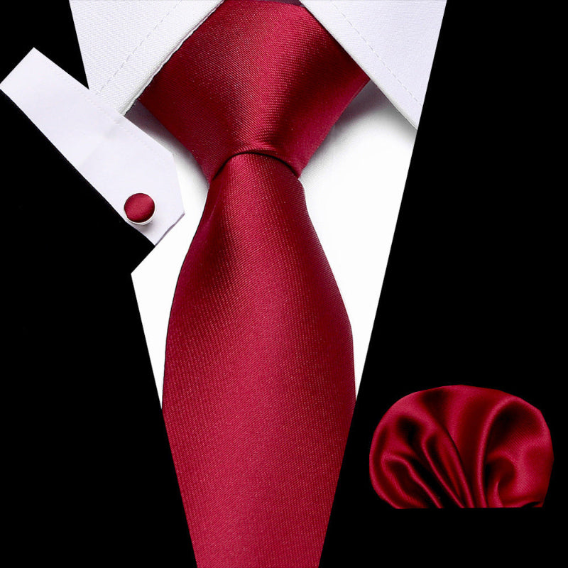 Red tie and matching pocket square on a white shirt with black background