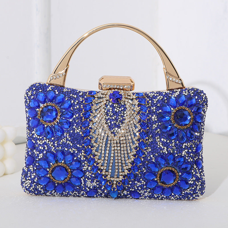 Blue handbag with floral patterns and gold accents on a white background