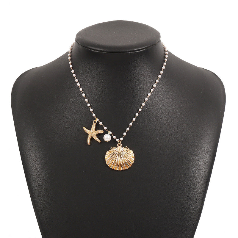 Necklace with starfish and shell charms on a black mannequin bust.