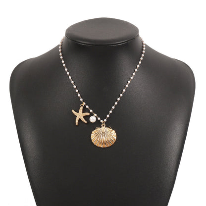 Necklace with starfish and shell charms on a black mannequin bust.