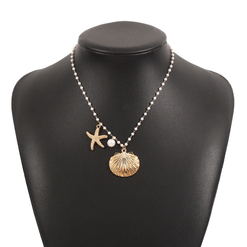 Gold-tone pearl necklace on bust with starfish and seashell charms