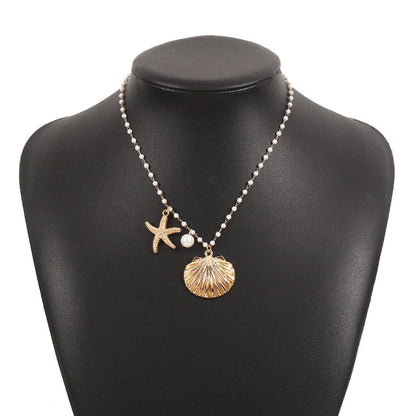 Gold-tone pearl necklace on bust with starfish and seashell charms