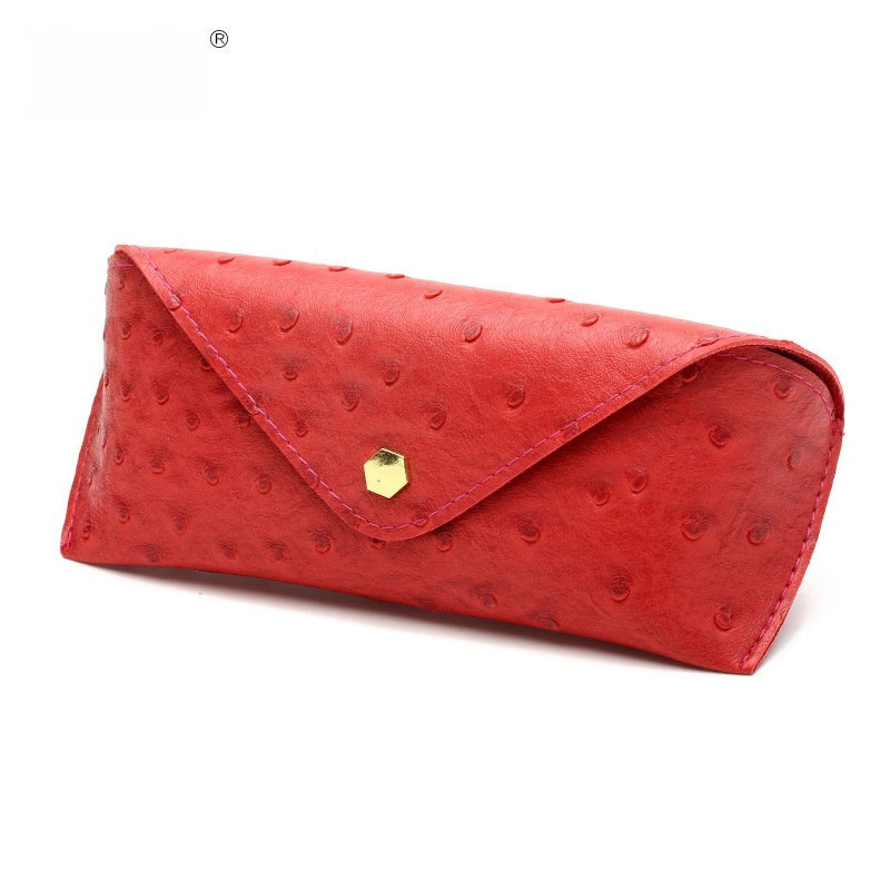 Red textured clutch bag with a gold clasp on a white background