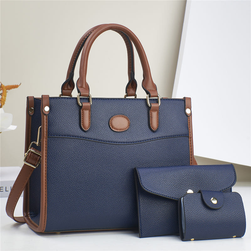 Three-piece shoulder bag set in navy with tan trim: structured tote plus two pouches