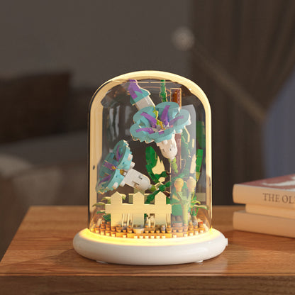 Decorative lamp with colorful butterfly figurines inside a glass dome on a wooden surface.