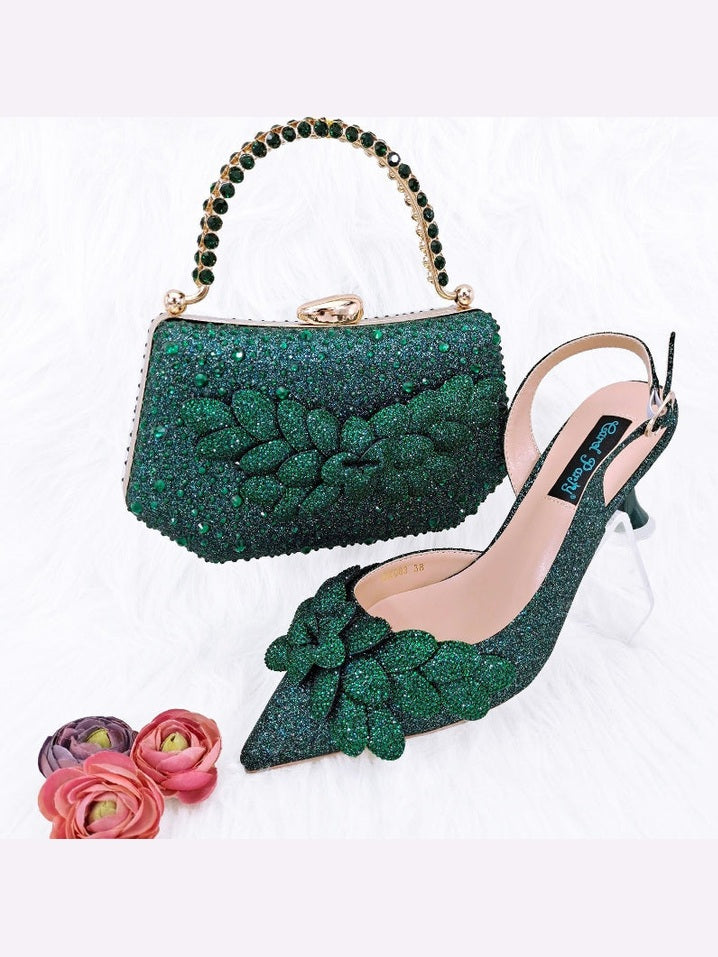 Green glittery handbag and high-heeled shoe with floral design on a white background