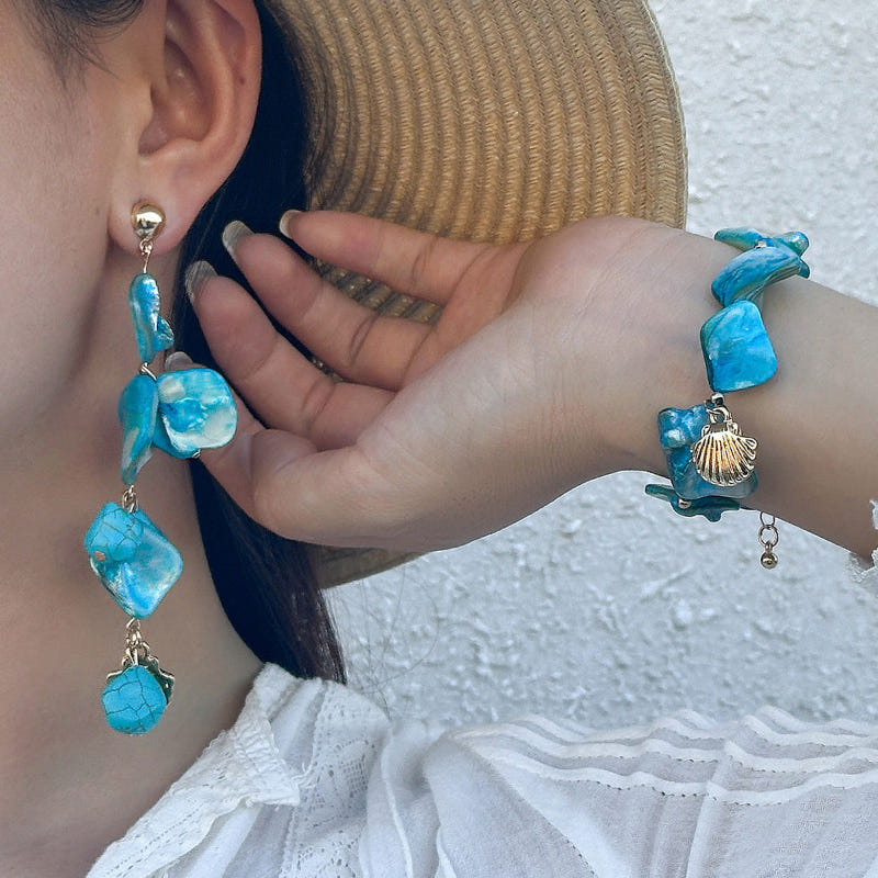 Blue shell drop earrings with gold-tone hooks and seashell charm accents