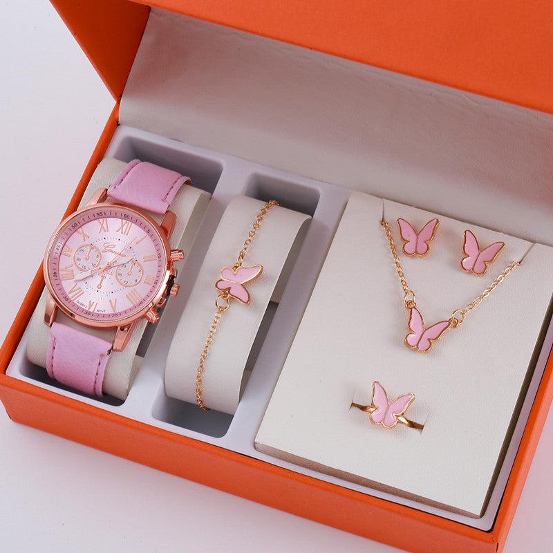 Jewelry set with pink watch, bracelet, necklace, and earrings in an orange box.