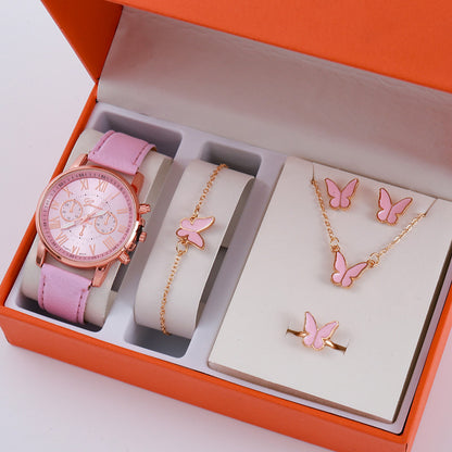 Jewelry set with pink watch, bracelet, necklace, and earrings in an orange box.