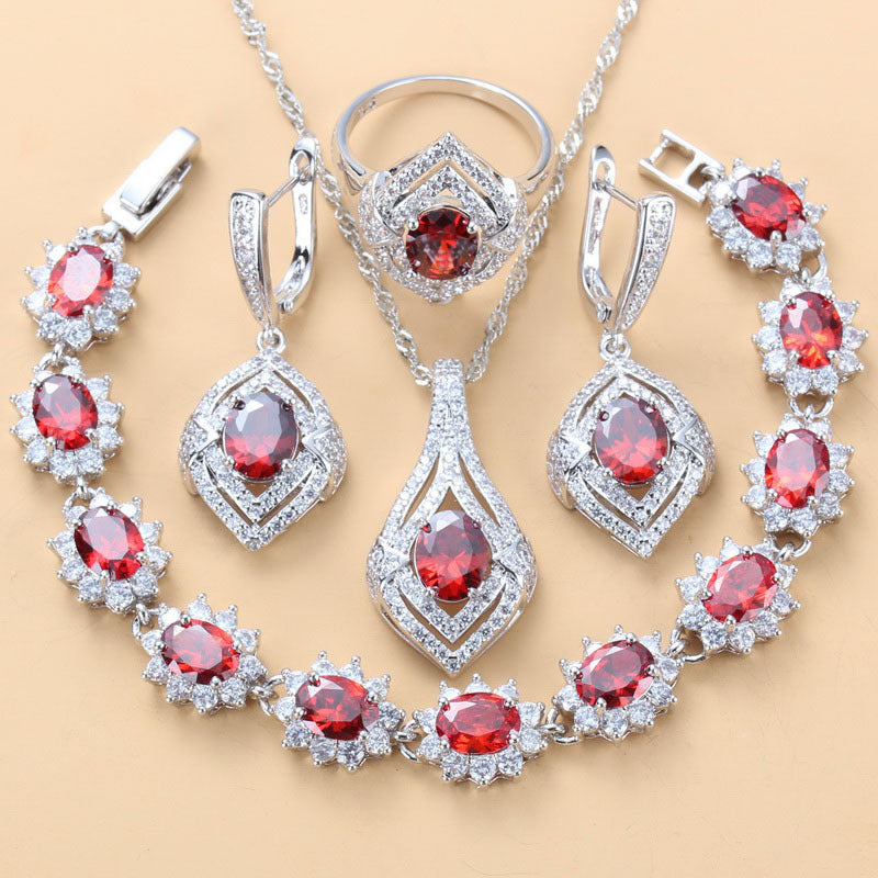 Red oval and round gemstone jewelry set with ring, pendant necklace, and drop earrings